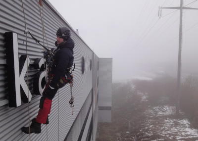 Leuchtwerbung montieren, Arbeit am hängenden Seil