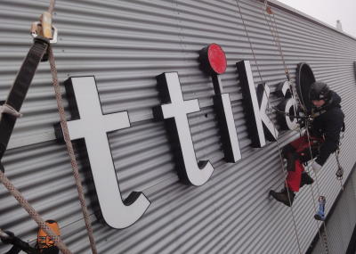 Leuchtwerbung montieren am Seil an schwer zugänglicher Stelle