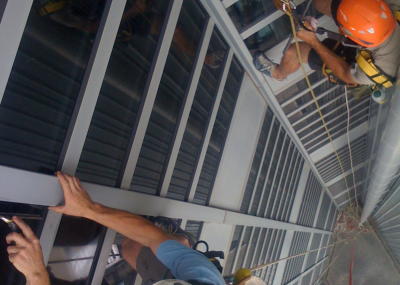 Industriekletterer bei Glasreinigung am hängenden Seil, Arbeit am Seil