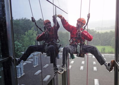 Fassadenkletterer bei Glasreinigung am hängenden Seil, Arbeit am Seil
