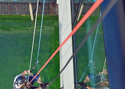 Glasreinigung am Seil in der Höhe, Gebäudereinigung mit Fassadenkletterer und Arbeit am Seil